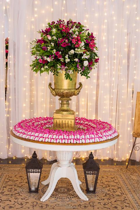 bem casado com vazo grande de flores vermelhas e brancas'