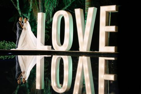 casal no love de luz com reflexo na piscina'