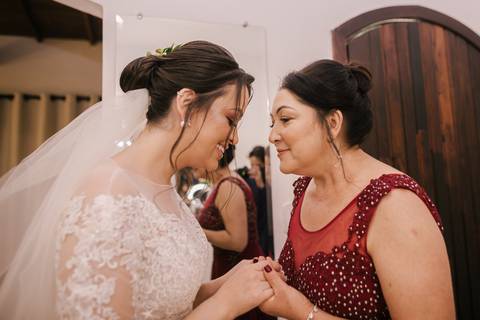 noiva e mãe antes da cerimonia de mãos dadas'