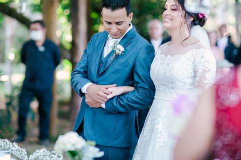 noivo acariciando mão noiva durante cerimonia'