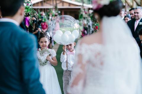 crinças entrando com alianças e casal ao meio'