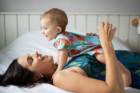 Bebê deitada sobre a mãe na cama, as duas sorrindo; Joao-Francisco-Fotografia; Familia; Niteroi; Rio de Janeiro; Acompanhamento; life-style;'
