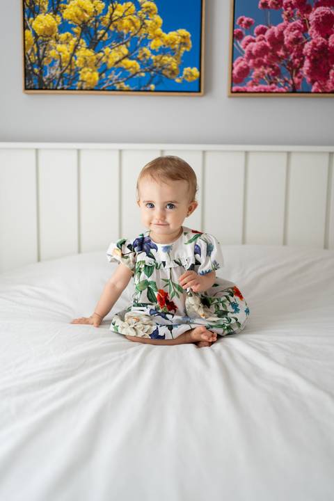Bebê sentada na cama de frente pra câmera, sorrindo; Joao-Francisco-Fotografia; Familia; Niteroi; Rio de Janeiro; Acompanhamento; life-style;'