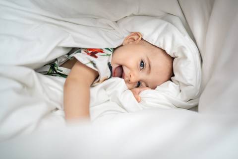 Bebê deitada de lado na cama com a língua pra fora; Joao-Francisco-Fotografia; Familia; Niteroi; Rio de Janeiro; Acompanhamento; life-style;'