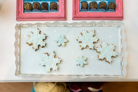 Detalhes da decoração da festa infantil de aniversário de 4 anos com o tema Frozen; princesa Elsa; princesa Anna; Biscoito em formato de flocos de neve'