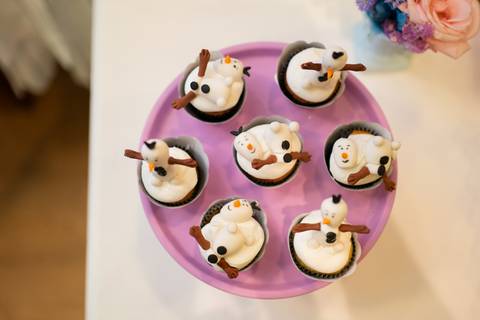 Detalhes da decoração da festa infantil de aniversário de 4 anos com o tema Frozen; princesa Elsa; princesa Anna; docinhos em formato de boneco de neve'