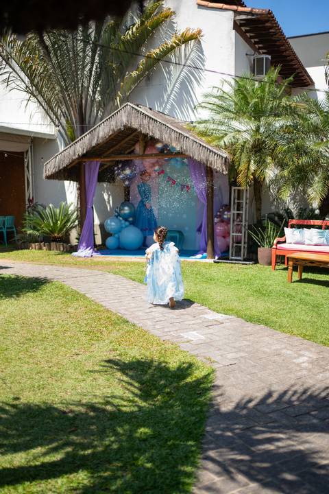 Festa infantil de aniversário de menina de 4 anos com o tema Frozen; princesa Elsa; princesa Anna; vestido azul; menina correndo na grama'