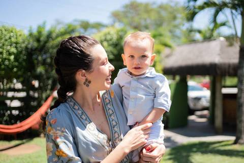 Festa infantil de aniversário de menina de 4 anos; mãe segurando bebê no colo com roupa azul; quintal de contos; niteroi; Rio de Janeiro; fotografo de familia'