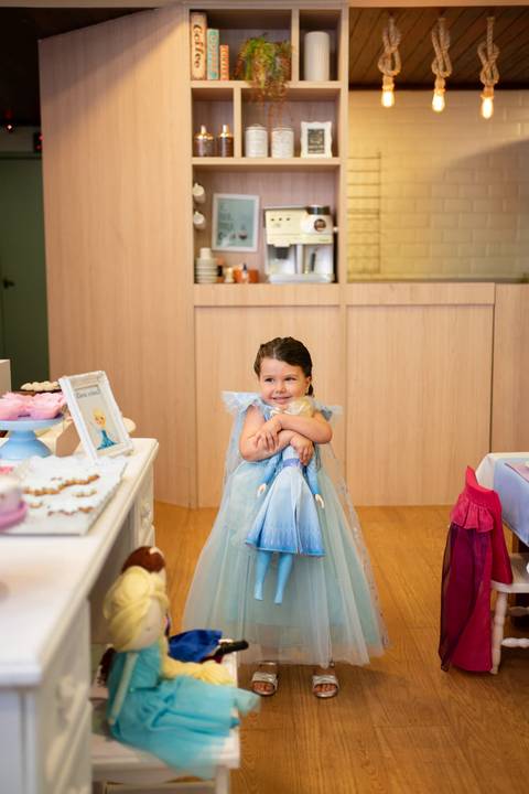 Festa infantil de aniversário de menina de 4 anos com o tema Frozen; princesa Elsa; princesa Anna; vestido azul; retrato menina abraçando boneca; quintal de contos; niteroi; Rio de Janeiro; fotografo de familia'