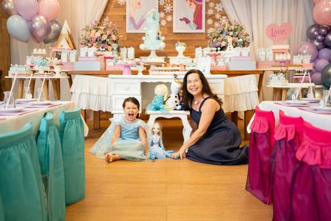 Festa infantil de aniversário de menina de 4 anos com o tema Frozen; princesa Elsa; princesa Anna; vestido azul; avó e neta sentadas no chão sorrindo para a foto; quintal de contos; niteroi; Rio de Janeiro; fotografo de familia'