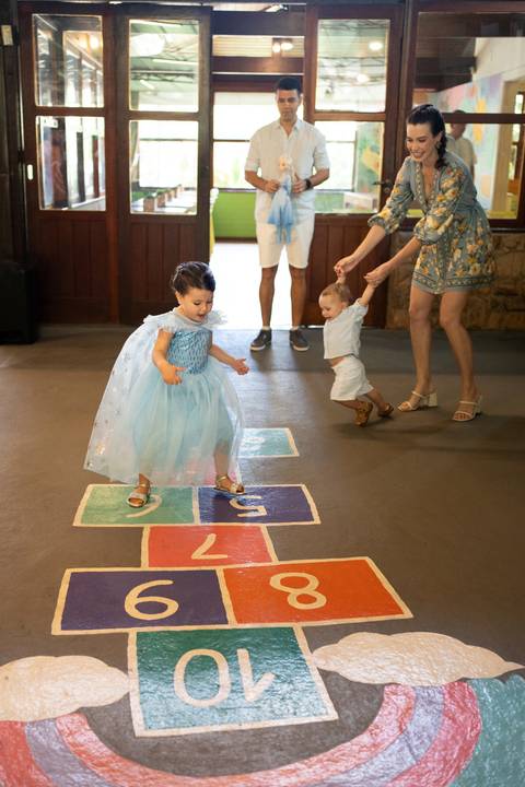 Festa infantil de aniversário de menina de 4 anos com o tema Frozen; princesa Elsa; princesa Anna; vestido azul; pulando amarelinha'