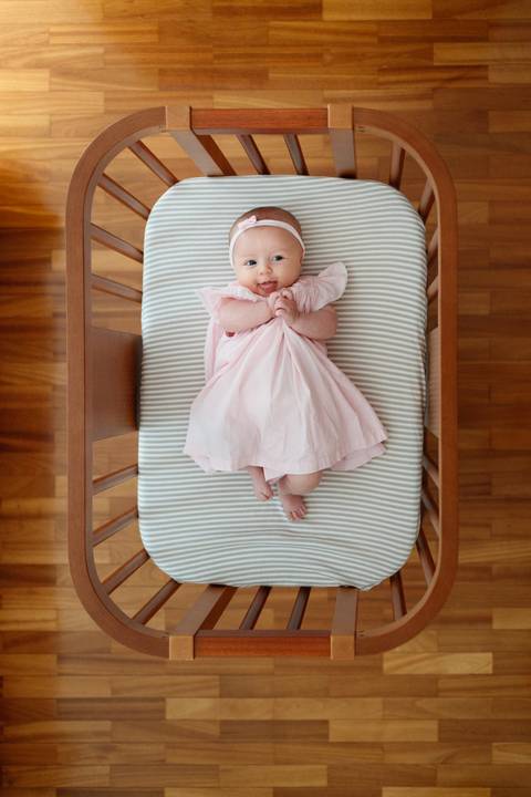 Bebê menina de 3 meses deitada no berço olhando para o alto; foto tirada de cima pra baixo; berço de madeira; Joao-Francisco-Fotografia; Familia; Niteroi; Rio de Janeiro; Acompanhamento; life-style;'