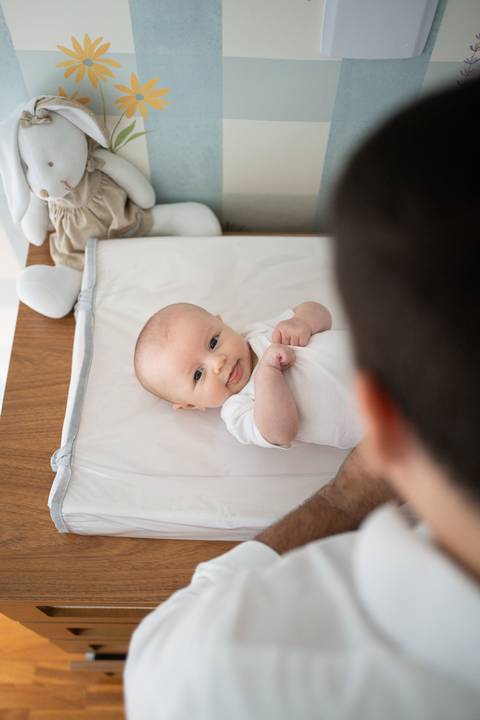 Ensaio familia; Acompanhamento; Bebe; Menina; 3 meses; em casa; Life Style; Joao-Francisco; Fotografia; Sessão; Fotos; pai trocando a roupa do bebê; bebê no trocador; bebê de branco'