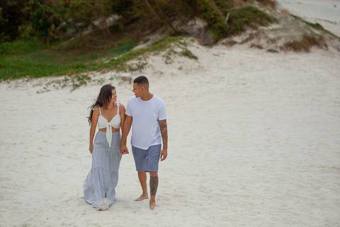 Casal de noivos andando na praia das dunas em Cabo Frio'