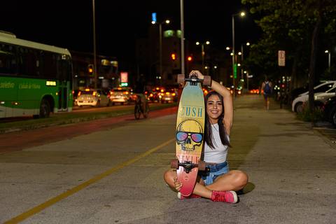 menina segurando skate'