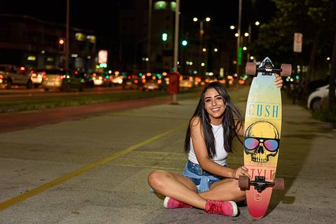 menina feliz segurando skate'