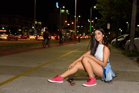 pose sentada no skate em ensaio noturno'