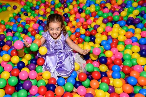 menina na piscina de bolinhas coloridas'