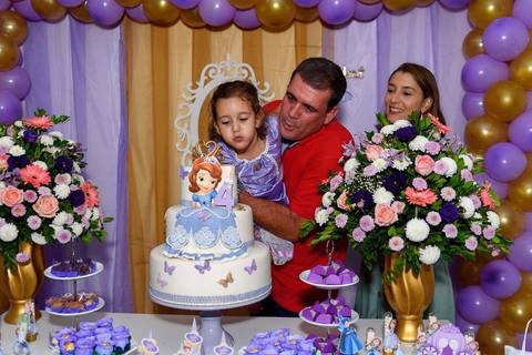 menina cantando parabéns e assoprando a vela'