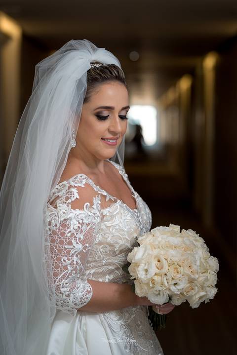 Noiva olhando o Buquê no corredor do Hotel CDesing '