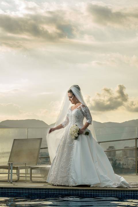 Noiva ajeitando o véu na beirada da piscina do hotel CDesign'