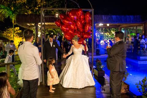 Noiva entrando na festa com balões de coração Espaço Paradisus'