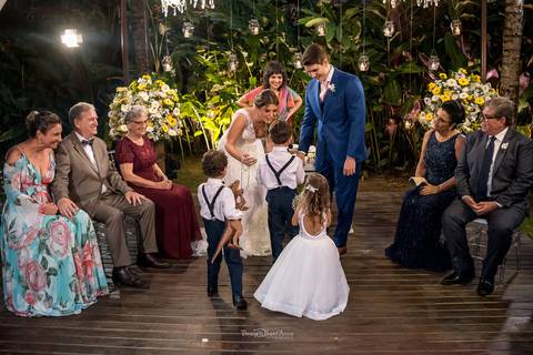noivos recebem pajem com as alianças familiares observam decoração flores brancas e amarelas '