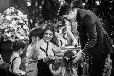 noivos recebem pajem com as alianças preto e branco'