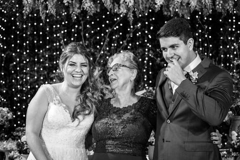 noivos riem junto a senhora decoração ambiente interno preto e branco '