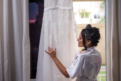 noiva observa seu vestido pendurado '