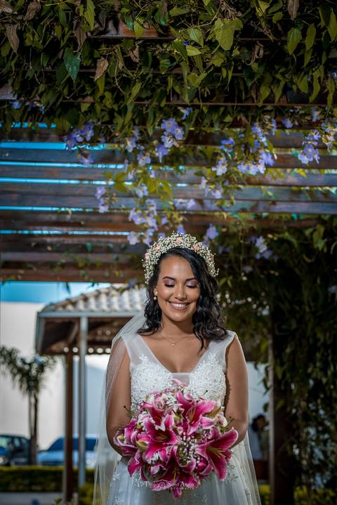 noiva sorri vestido buque estrutura de madeira com vegetação flores lilás'