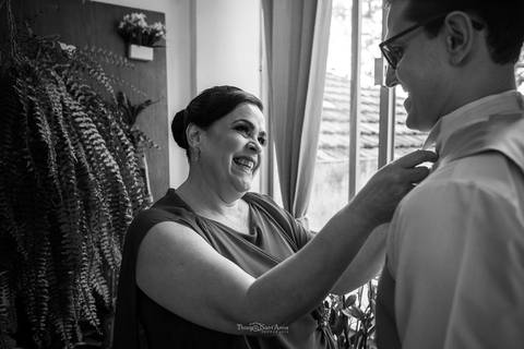 mãe do noivo arruma sua gravata '