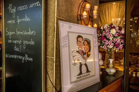 quadro caricatura dos noivos flores em tons de rosa quadro negro escrita'