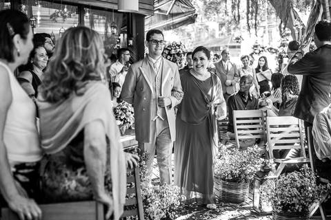 entrada do noivo com sua mãe convidados observam de pé preto e branco'