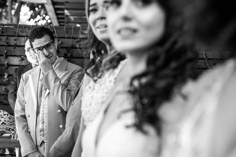 convidados observam a chegada da noiva noiva se emociona preto e branco'