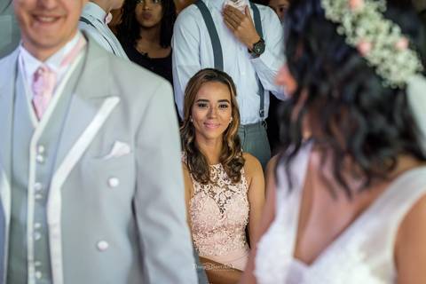 madrinha sorri observando os noivos '