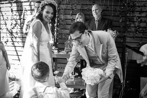 noivo recebe o pajem com as alianças noiva sorri preto e branco'