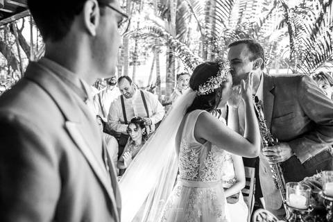 pai da noiva beija sua testa noivo observa preto e branco'