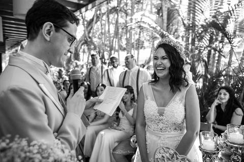 noivo lê seus votos de casamento noiva sorri padrinhos observam sorrindo preto e branco'