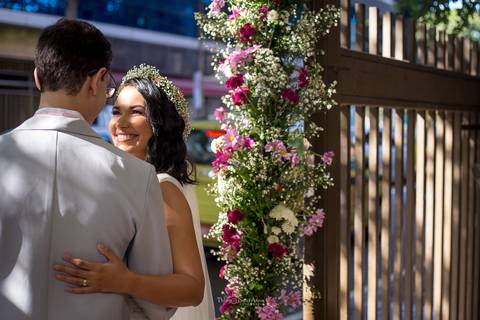 noivos se observam sorrindo abraçados decoração flores em tons de rosa'