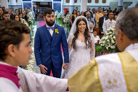 noivos no altar noiva sorri convidados ao fundo '