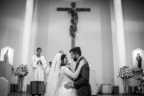 beijo dos noivos no altar preto e branco'