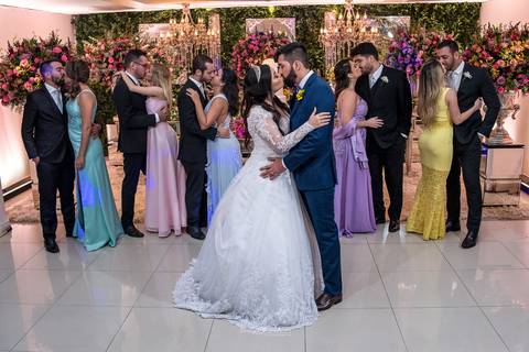 noivos se beijam padrinhos e madrinhas se beijam decoração lustres e flores em tons de rosa'