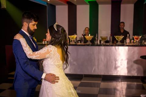 noivos dançam na pista bar ao fundo'