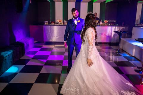 noivos dançam na pista bar ao fundo'