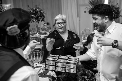 padrinhos sorrindo senhora contribui com caixinha dos noivos preto e branco'