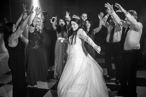 noiva dança na pista padrinhos estendem as mão preto e branco'