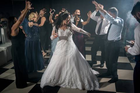 noiva sorri dança na pista padrinhos estendem as mãos '