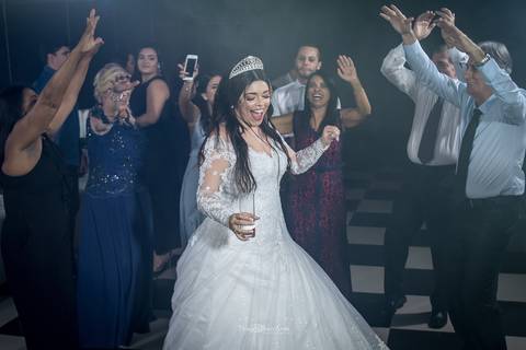 noiva sorri com copo na mão dança na pista com padrinhos '