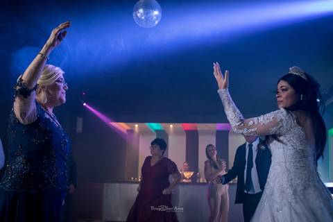 noiva dança na pista com sua mãe convidados e bar ao fundo '